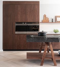 a kitchen with marble counter tops and wooden cabinets, along with an oven in the center