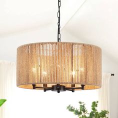 a chandelier hanging from the ceiling in a room with white walls and curtains