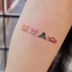 a woman's arm with three little bears on it and one is holding onto the other