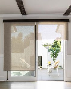 a living room with sliding glass doors and blinds