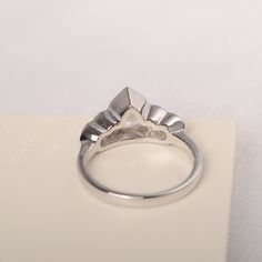 a silver ring sitting on top of a piece of white paper next to a pair of scissors