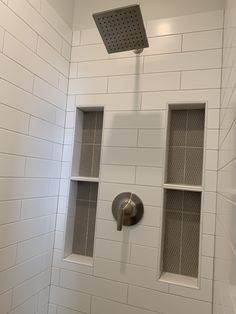 the shower head is mounted to the side of the wall in this white tiled bathroom