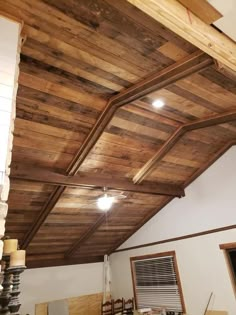 an unfinished ceiling with wooden beams and lights