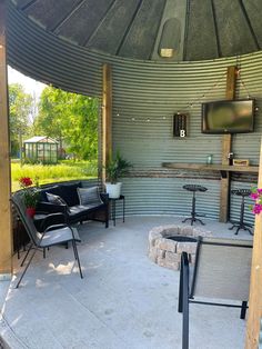 a patio area with chairs, tables and television