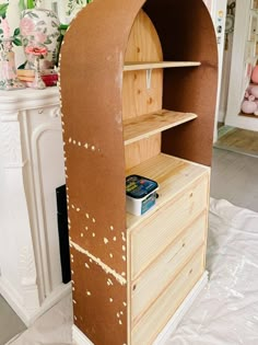 a wooden shelf with some kind of food in it on top of a white sheet