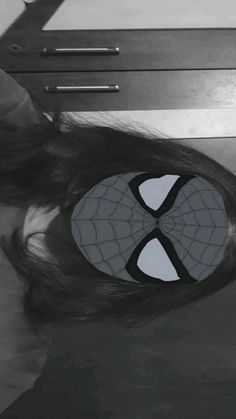 a woman with her hair in the shape of a spider - man's face