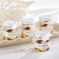 four jars of honey sit on a tray