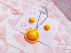 a necklace and earring set is shown on a pink background with heart - shaped shapes