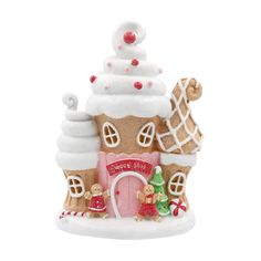 a ceramic gingerbread house with white frosting and decorations on the roof, front view