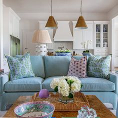 a living room filled with blue couches and lots of pillows on top of it