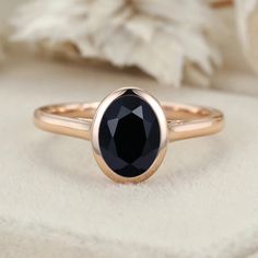 a black diamond ring sitting on top of a white cloth