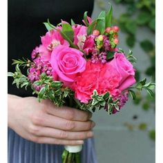 a woman holding a bouquet of pink flowers