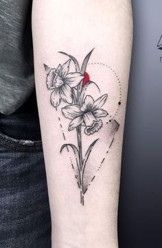 a black and white photo of a flower tattoo on the right arm, with a red spot in the middle