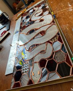 a wooden table topped with lots of different types of glass and metal items on top of it