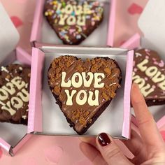 chocolate heart shaped cookies with the words love you written on them in a pink box