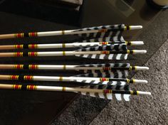 several arrows are lined up in a row next to a coffee table with a cup on it