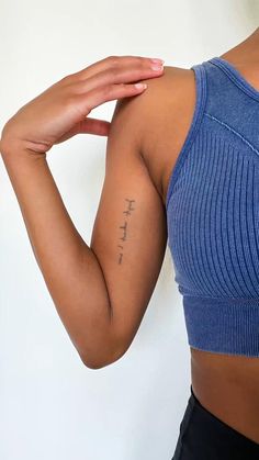 a close up of a person with a tattoo on her arm and hand behind her head