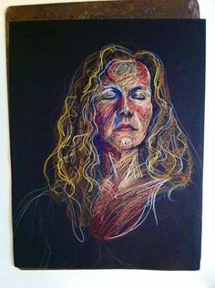 a drawing of a woman's face on a black paper with colored crayons