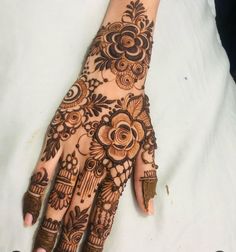 a henna on someone's hand that is showing the intricate designs and colors