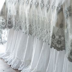 several white bedspreads are lined up against the wall