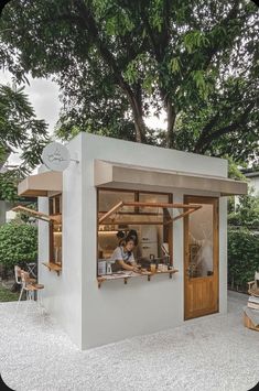 a person sitting at a counter in a small building