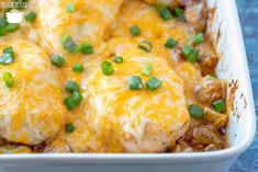 a casserole dish with chicken, mushrooms and green onions in it on a blue surface