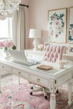 a white desk topped with a laptop computer sitting on top of a pink rug next to a window