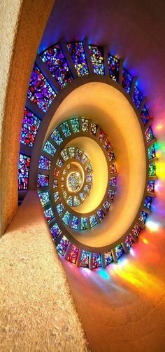 the inside of a spiral shaped object with colorful lights coming from it and in the center