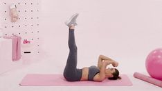 a woman doing an exercise on a pink mat