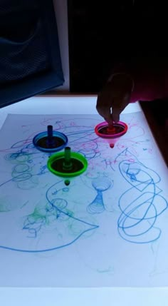 a person is drawing on a table with markers