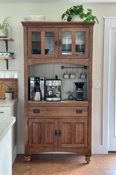 a wooden cabinet sitting in the middle of a kitchen