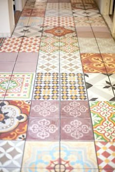 a kitchen floor covered in colorful tiles