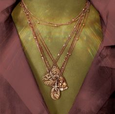 a close up of a person wearing a green shirt and some necklaces on their neck