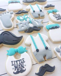 decorated cookies are arranged on a table with blue and white decorations, including mustaches