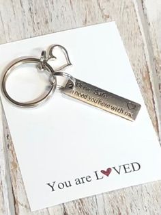 a keychain with a message on it that says, you are loved