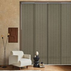 a living room with a couch, chair and sliding glass door that has blinds on it