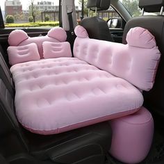 an inflatable car seat that is pink and has two pillows on the back