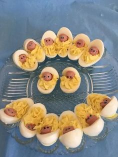 there are some deviled eggs in the shape of pigs and chicks on a glass platter