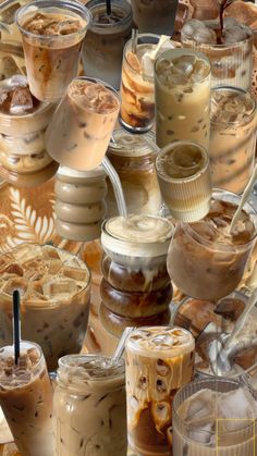 there are many different types of drinks in the cups on this table together, including iced coffee and milkshakes