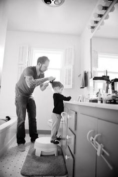 a man standing next to a little boy in a bathroom