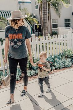 a woman holding the hand of a small child