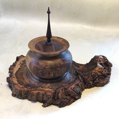 a wooden tea pot sitting on top of a tree stump