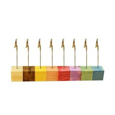 several different colored pencils are lined up in a row with gold pins sticking out of them