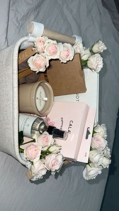 the contents of a woman's purse laid out on top of a bed with flowers