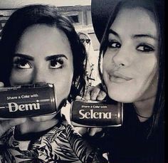 two women are holding up some kind of item in front of their faces with the words selena on them