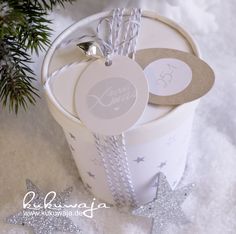 a christmas present in a white bucket with silver bells and tags on the tag that says love you