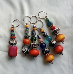 several different colored beads and charms on a white sheet