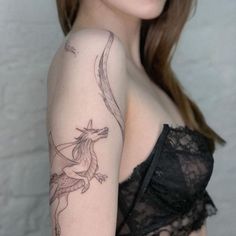 a woman with a dragon tattoo on her arm