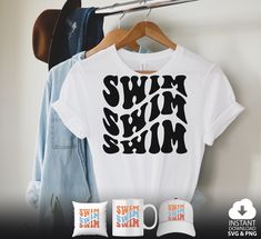 a white shirt with the words swimin'in black on it next to two mugs