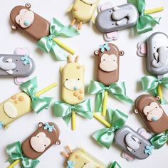 there are many different shaped cookies with animals on them and green ribbons around the bears